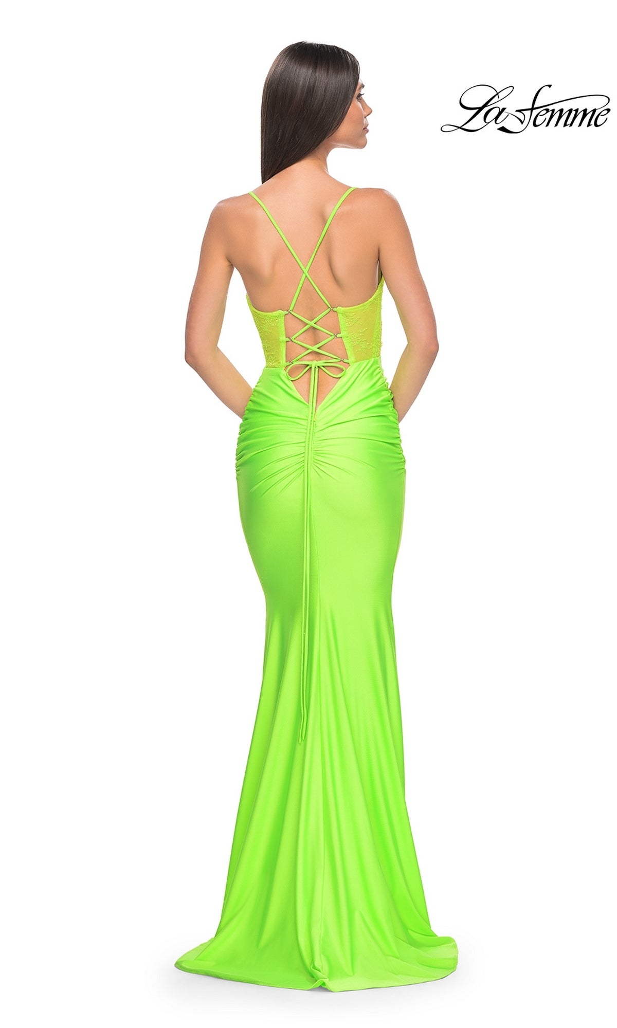 Woman in a neon green La Femme Sheer-Bodice Long Prom Dress 32322, featuring a lace-up open back and thin straps, stands with her back to the camera.